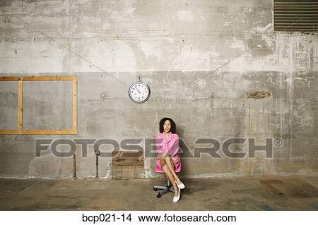 Young woman sitting under a clock View Large Photo Image Picture - Young woman sitting under a clock. Fotosearch