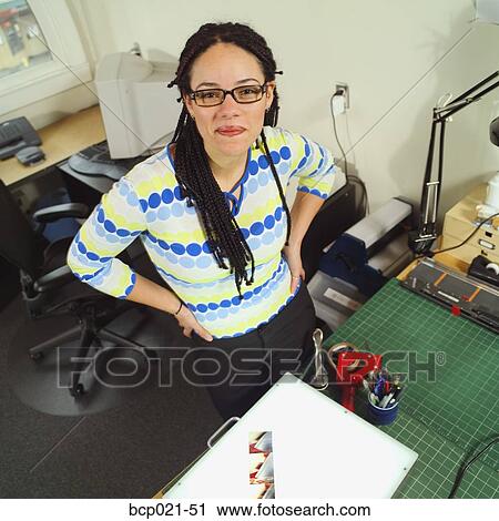 Young woman working in an office View Large Photo Image Stock Image - Young woman working in an office. Fotosearch