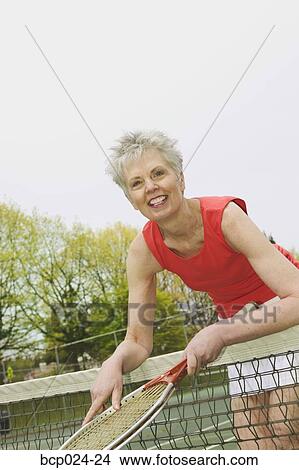 Picture - A middle-aged woman playing tennis. Fotosearch