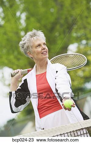 Stock Image - A middle-aged woman playing tennis. Fotosearch