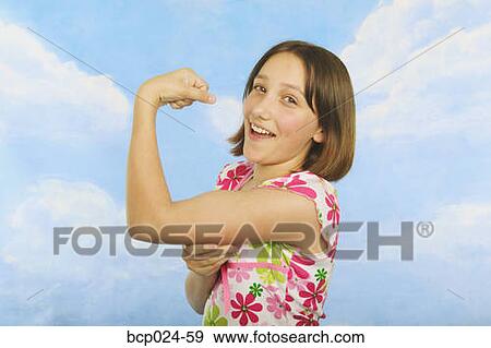 A teenaged girl flexing her muscles View Large Photo Image Stock Photo - A teenaged girl flexing her muscles. Fotosearch
