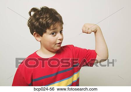 Stock Photograph - A young boy flexing his muscles. Fotosearch