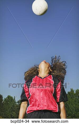 A young woman heading a soccer ball View Large Photo Image Picture - A young woman heading a soccer ball. Fotosearch