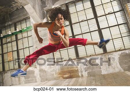 A young woman leaping in the air View Large Photo Image Stock Image - A young woman leaping in the air. Fotosearch
