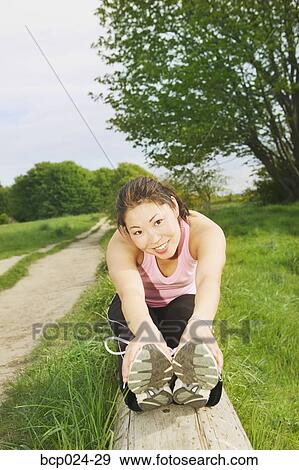 Stock Photo - A young woman smiling and stretching. Fotosearch