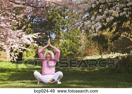 Stock Photo - An older woman in a yoga position. Fotosearch