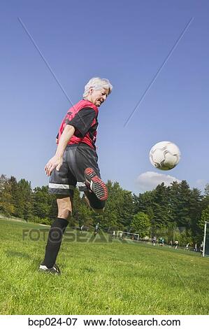An older woman playing soccer View Large Photo Image Stock Photo - An older woman playing soccer. Fotosearch
