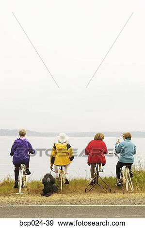 Stock Photo - Four women on stationary bikes. Fotosearch