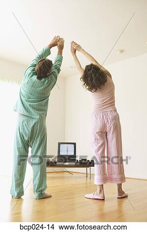 Middle-aged couple exercising to a TV program View Large Photo Image Picture - Middle-aged couple exercising to a TV program. Fotosearch