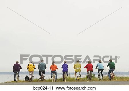 Stock Image - Nine people riding stationary bikes. Fotosearch