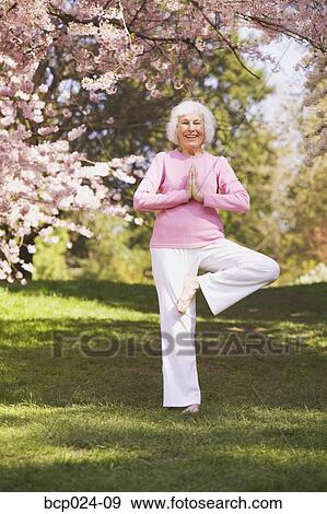 Older woman in a yoga position View Large Photo Image Stock Photo - Older woman in a yoga position. Fotosearch