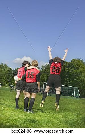 Stock Photo - Three female soccer players celebrate a win. Fotosearch