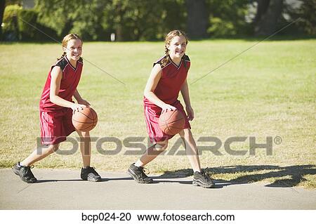 Twin teen girls dribbling basketballs View Large Photo Image Stock Image - Twin teen girls dribbling basketballs. Fotosearch