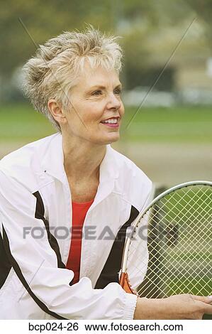Stock Photograph - White middle-aged woman playing tennis. Fotosearch