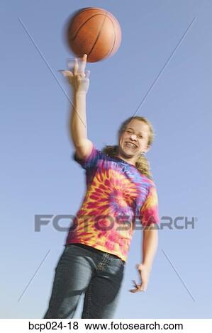 Stock Photo - Young female teenaged girl spinning a basketball. Fotosearch