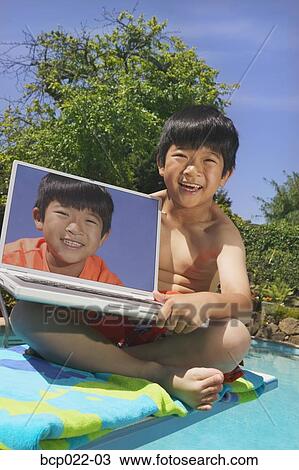 A 若い少年 プールサイド で A ラップトップ コンピュータ ストックイメージ p022 03 Fotosearch