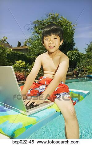 A boy sitting on a diving board with his laptop View Large Photo Image Stock Photography - A boy sitting on a diving board with his laptop. Fotosearch