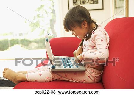 A little girl using her laptop computer View Large Photo Image Stock Photo - A little girl using her laptop computer. Fotosearch