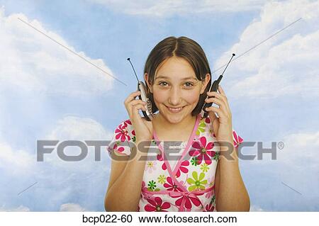 A teenaged girl with two mobile phones View Large Photo Image Stock Image - A teenaged girl with two mobile phones. Fotosearch