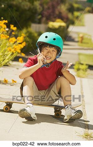 A young skateboarder talking on his mobile phone View Large Photo Image Stock Image - A young skateboarder talking on his mobile phone. Fotosearch