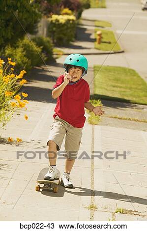 A young skateboarder talking on his mobile phone View Large Photo Image Stock Image - A young skateboarder talking on his mobile phone. Fotosearch