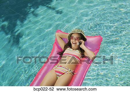 Girl talking on a mobile phone in a pool View Large Photo Image Stock Image - Girl talking on a mobile phone in a pool. Fotosearch