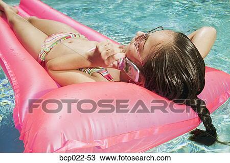 Girl talking on a mobile phone in a pool View Large Photo Image Stock Image - Girl talking on a mobile phone in a pool. Fotosearch