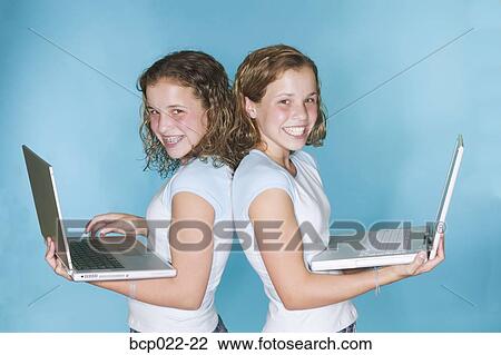 Teen twin girls using laptop computers View Large Photo Image Stock Image - Teen twin girls using laptop computers. Fotosearch
