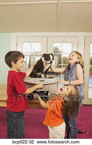 Three kids faxing a dog View Large Photo Image Stock Image - Three kids faxing a dog. Fotosearch