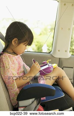 Young Asian girl in car seat with electronic toy View Large Photo Image Stock Photo - Young Asian girl in car seat with electronic toy. Fotosearch
