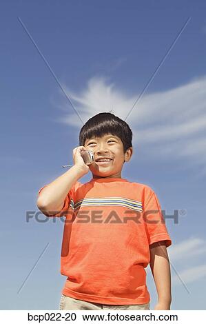 Young boy using his mobile phone View Large Photo Image Stock Image - Young boy using his mobile phone. Fotosearch