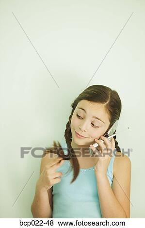Young girl listening on her mobile phone View Large Photo Image Stock Photo - Young girl listening on her mobile phone. Fotosearch
