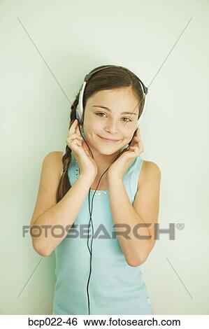 Young girl listening to music with a headset View Large Photo Image Stock Photograph - Young girl listening to music with a headset. Fotosearch