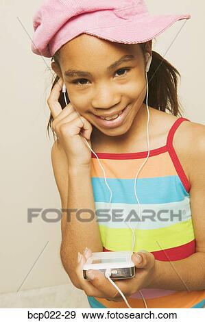 Stock Photo - Young girl listening to tunes on an MP3 player. Fotosearch