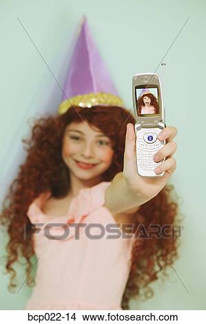 Young girl using a mobile phone with camera View Large Photo Image Picture - Young girl using a mobile phone with camera. Fotosearch