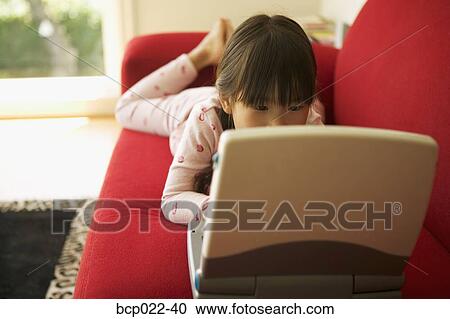Young girl working on a laptop View Large Photo Image Stock Image - Young girl working on a laptop. Fotosearch
