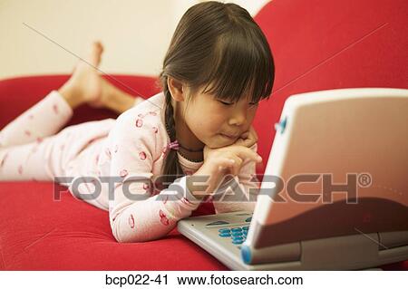 Young girl working on a laptop View Large Photo Image Stock Image - Young girl working on a laptop. Fotosearch