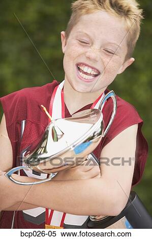 Stock Photography - A boy holding a trophy. Fotosearch