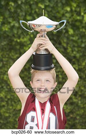 Boy balancing a trophy on his head View Large Photo Image Stock Image - Boy balancing a trophy on his head. Fotosearch