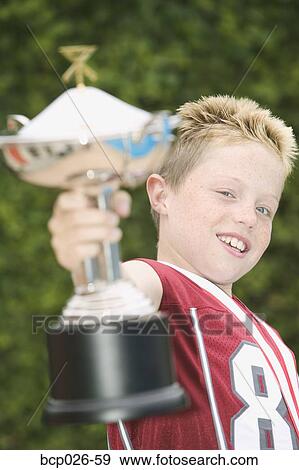 Boy holding a trophy View Large Photo Image Stock Photo - Boy holding a trophy. Fotosearch