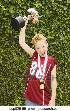 Boy holding a trophy View Large Photo Image Stock Photography - Boy holding a trophy. Fotosearch