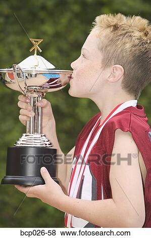 Boy holding and kissing a trophy View Large Photo Image Stock Photo - Boy holding and kissing a trophy. Fotosearch