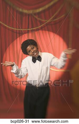 Stock Image - Boy on stage making hand gestures. Fotosearch