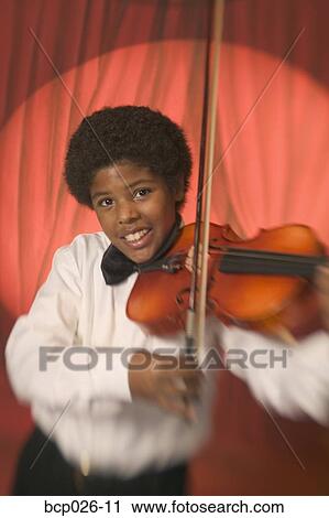 Boy on stage playing the violin View Large Photo Image Stock Image - Boy on stage playing the violin. Fotosearch