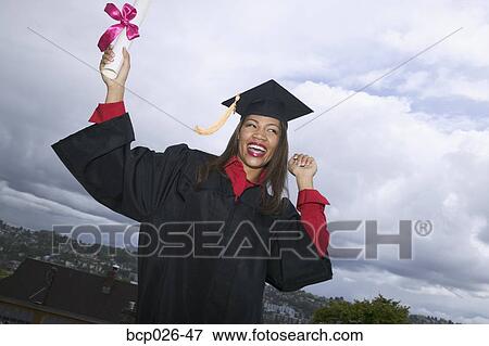 Female graduate holding her diploma View Large Photo Image Stock Photo - Female graduate holding her diploma. Fotosearch