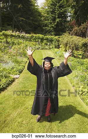 Graduating woman wearing cap and gown View Large Photo Image Stock Image - Graduating woman wearing cap and gown. Fotosearch