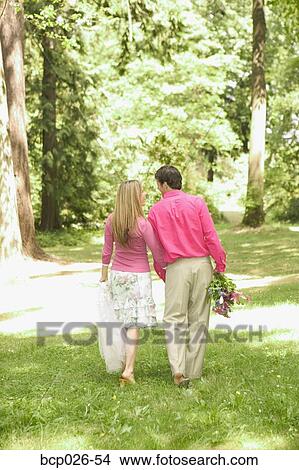 Newlywed couple walking through a park View Large Photo Image Picture - Newlywed couple walking through a park. Fotosearch