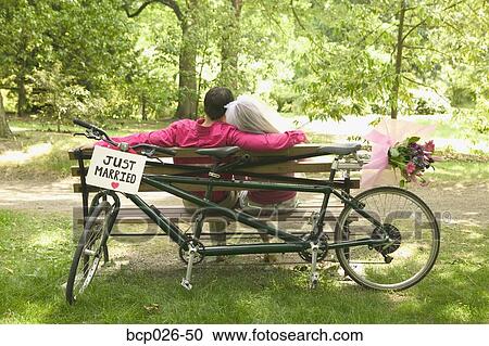 Newlyweds relax after a bicycle ride View Large Photo Image Stock Image - Newlyweds relax after a bicycle ride. Fotosearch
