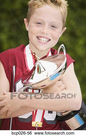 Portrait of a boy hugging a trophy View Large Photo Image Stock Photograph - Portrait of a boy hugging a trophy. Fotosearch