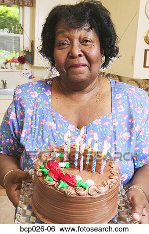 Woman holding a cake with candles View Large Photo Image Stock Photograph - Woman holding a cake with candles. Fotosearch